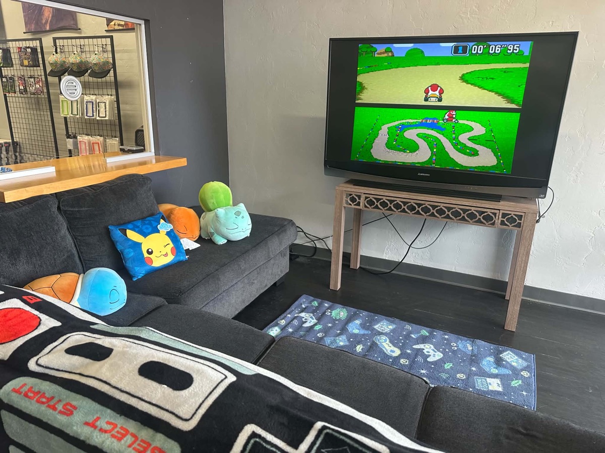 OKC RIPS game lounge — couch, retro Mario Kart on the TV and Pokémon plush